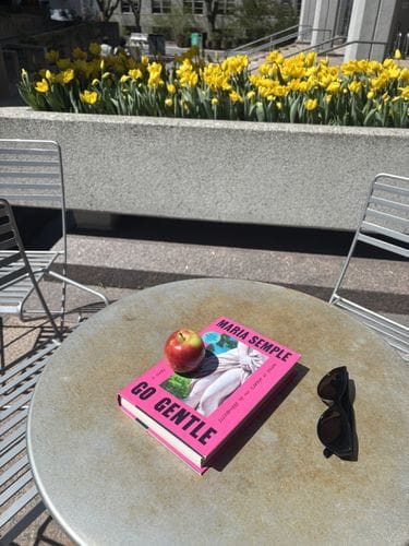 a book and handheld fruit in sunshine