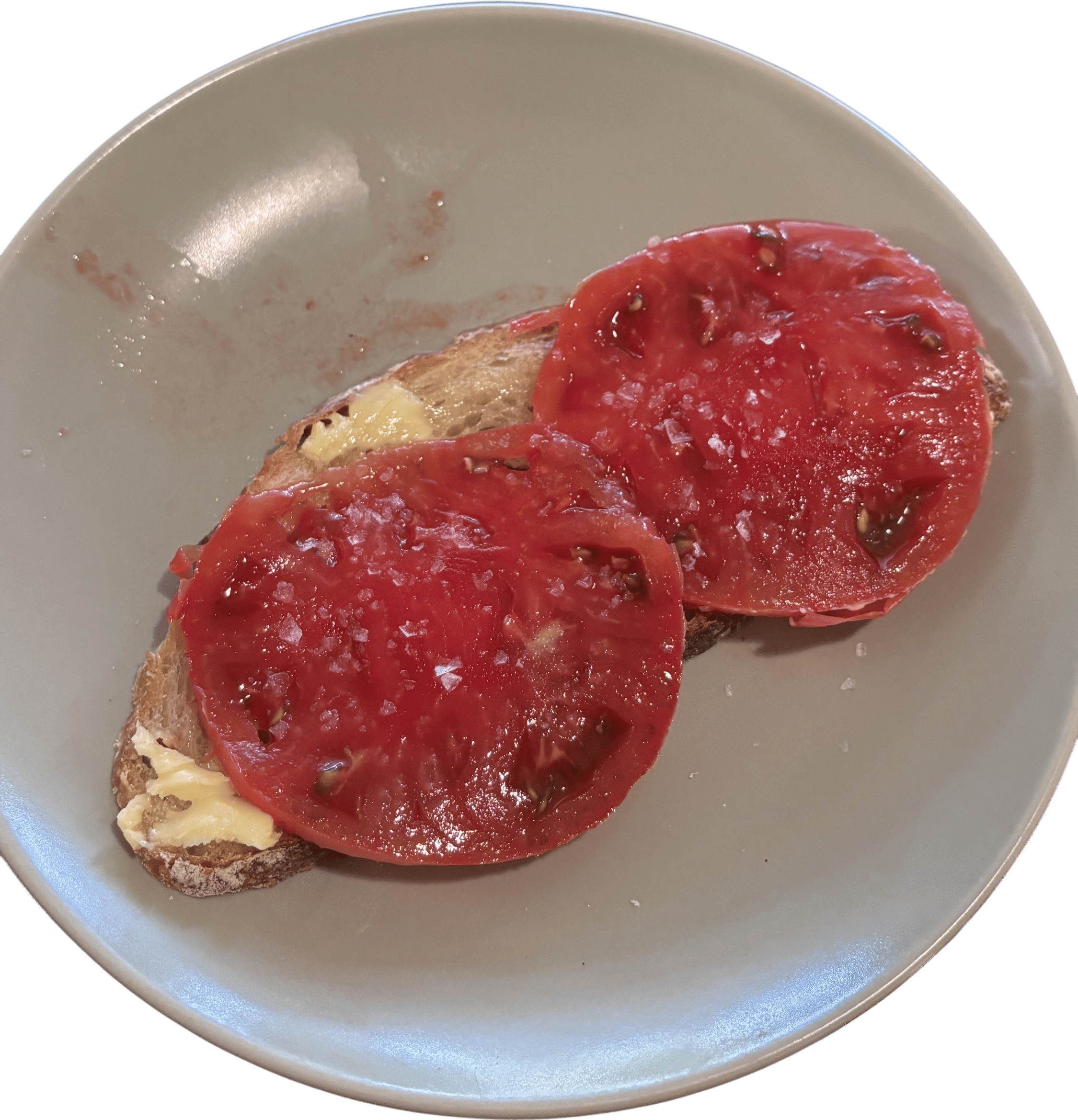 slice of sourdough with butter, heirloom tomato, and flakey salt