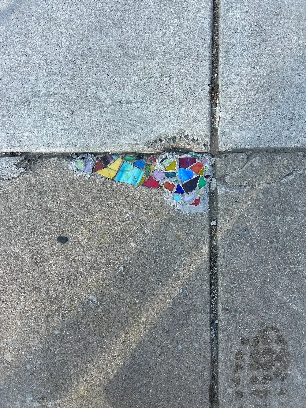 Putting mosaic tiles in sidewalk cracks