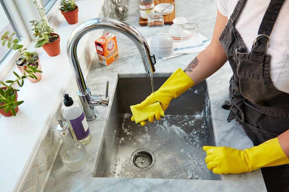 Wearing rubber gloves while cleaning dishes