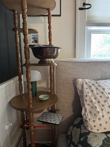 a midcentury plant stand as a night stand
