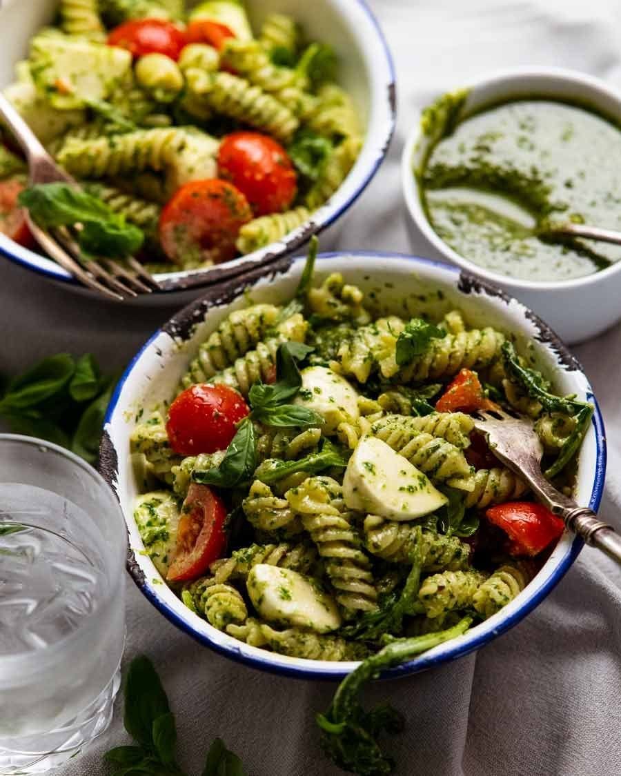 Pasta, jar of pesto, black olives, cherry tomatoes, arugula, mozzarella balls or chucks