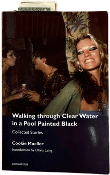 walking through clear water in a pool painted black