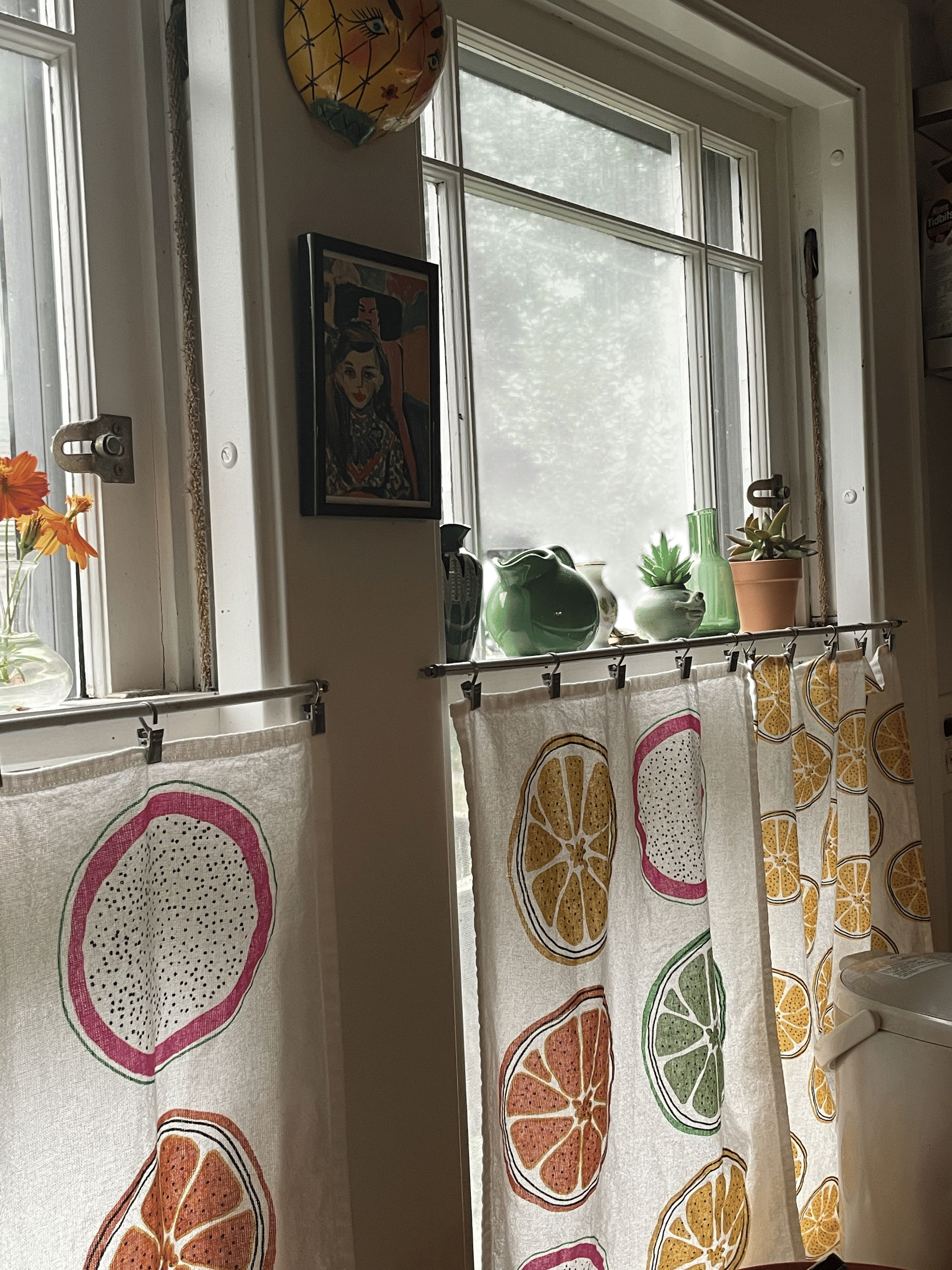 Using colorful tea towels from IKEA as kitchen bistro curtains.