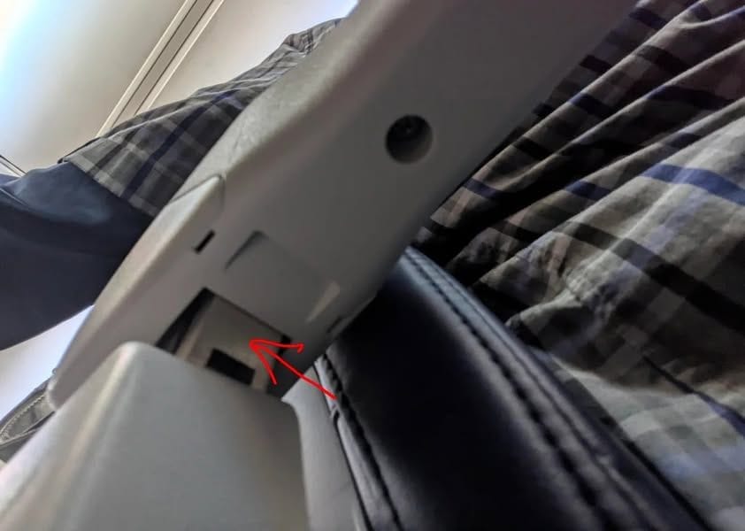 The secret button underneath an airplane aisle armrest that lets you raise it