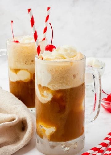 root beer, a stack of cups and a cooler with vanilla ice cream in it, some cute striped paper straws, jar or marischino cherries